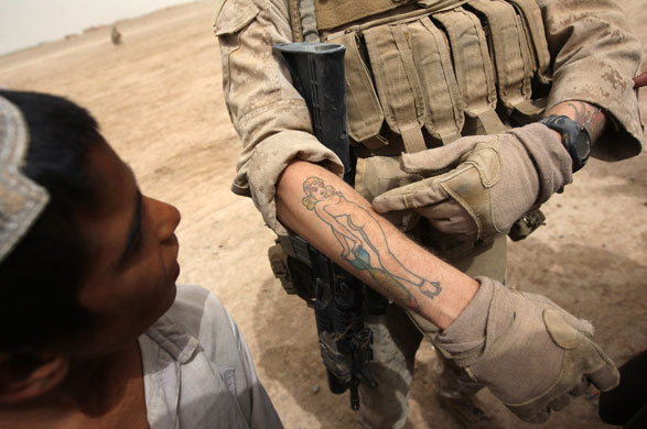 24 марта. Kirta, Афганистан Американский морской пехотинец хвастается татуировкой местному мальчику в то время патрульного рейда. John Moore/Getty