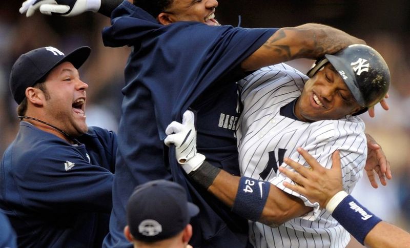 4) Отбивающий из бейсбольной команды «New York Yankees» Робинсон Кано обнимается со своими товарищами по команде после того, как они победили с разрывом в одно очко своих соперников, команду «Toronto Blue Jays» на стадионе Yankee 12 августа. (Ray Stubblebine/Reuters)