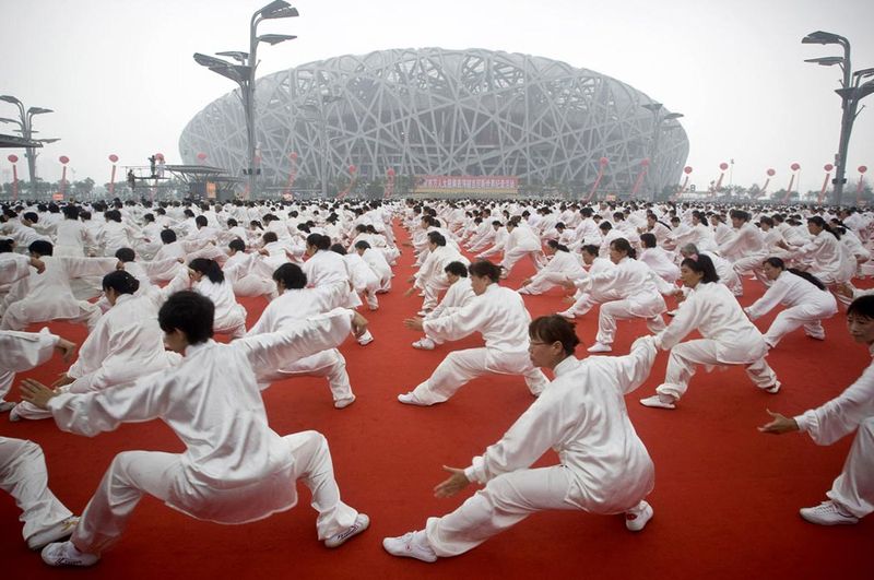 22) Десятки тысяч людей занимаются гимнастикой таи чи в честь годовщины открытия олимпийских игр в Пекине перед Китайским национальным стадионом в Пекине, Китай, 8 августа. (Alexander F. Yuan, AP)