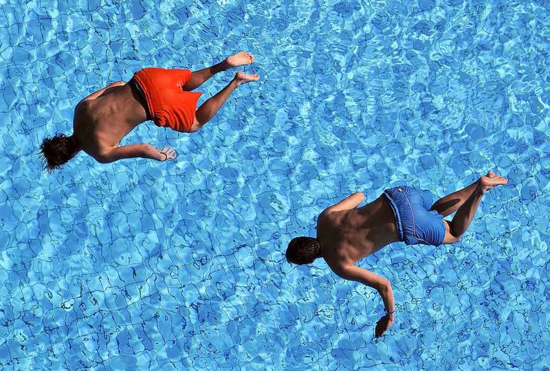 25) Молодые люди прыгают с вышки в бассейн в Штутгарте, Германия, 7 августа. (Daniel Maurer, AP)