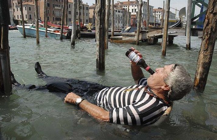 Гранд- Канал, Венеция, 5 августа. Picture: REUTERS. Гондольер пьет пиво сидя на садовом стуле прямо в Великом Канале. Температура воздуха 32 по Цельсию