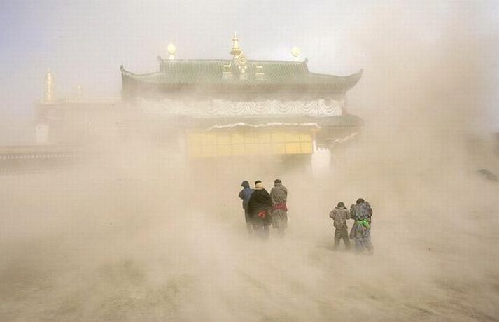 Абе, область Сычуань, 17 февраля. ФОТО: РЕЙТЕР Тибетские паломники входят в монастырь в дни буддийского праздника Monlam, во время песчаной бури.